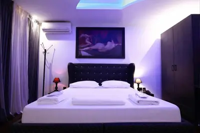 a bedroom with a large white bed with purple lighting at Comfort Room 216 - Castle De Paris in Athens