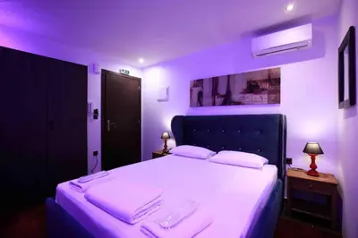 a bedroom with a large bed with purple lighting at Comfort Room 217 - Castle De Paris in Athens