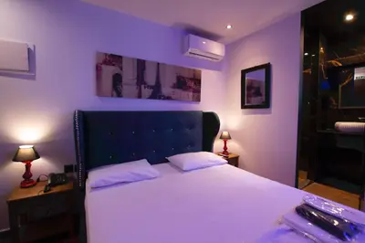 a bedroom with a large white bed with purple walls at Comfort Room 217 - Castle De Paris in Athens