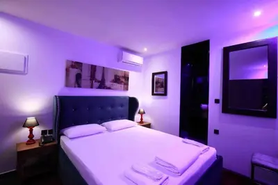 a purple bedroom with a bed with two towels on it at Comfort Room 217 - Castle De Paris in Athens