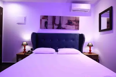 a purple bedroom with a large bed with two lamps at Comfort Room 217 - Castle De Paris in Athens