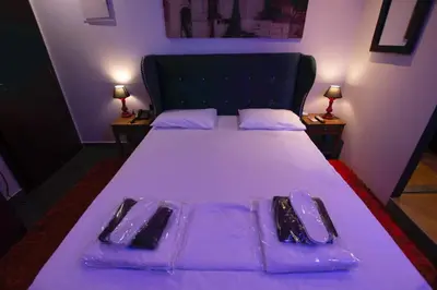 a bed with purple sheets and utensils on it at Comfort Room 217 - Castle De Paris in Athens