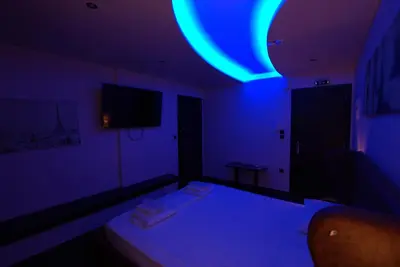 a dark room with a bed with a blue light at Comfort Room 218 - Castle De Paris in Athens