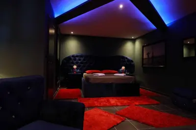 a dark room with a bed with a red rug at Deluxe Suite 211 - Castle De Paris in Athens