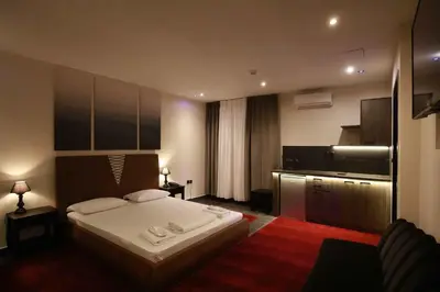 a bedroom with a large bed and a kitchen at Deluxe Suite 212 - Castle De Paris in Athens