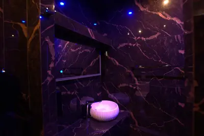 a bathroom with a purple stone wall with a lighted sink at Deluxe Suite 212 - Castle De Paris in Athens