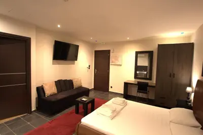 a living room with a white couch and a chair at Deluxe Suite 212 - Castle De Paris in Athens