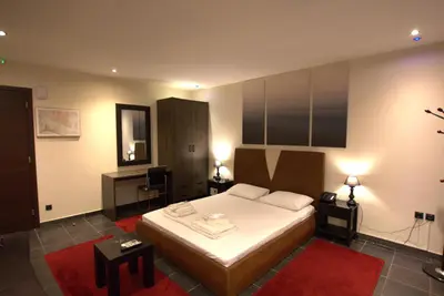 a bedroom with a bed and a desk in it at Deluxe Suite 212 - Castle De Paris in Athens