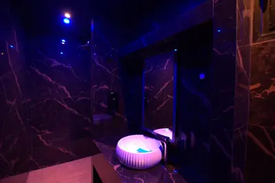 a bathroom with a lit up toilet in a dark room at Deluxe Suite 213 - Castle De Paris in Athens