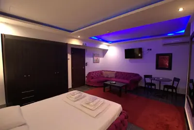 a living room with a couch and a table with chairs at Deluxe Suite 213 - Castle De Paris in Athens