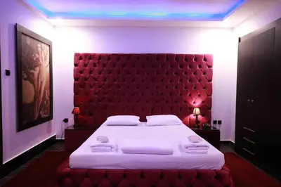 a bedroom with a large bed with a red headboard at Deluxe Suite 213 - Castle De Paris in Athens