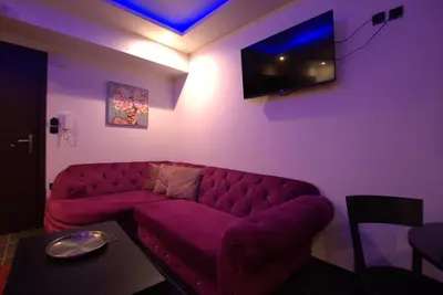 a living room with a purple couch and a tv at Deluxe Suite 213 - Castle De Paris in Athens