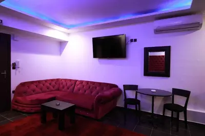 a living room with a red couch and a tv at Deluxe Suite 213 - Castle De Paris in Athens