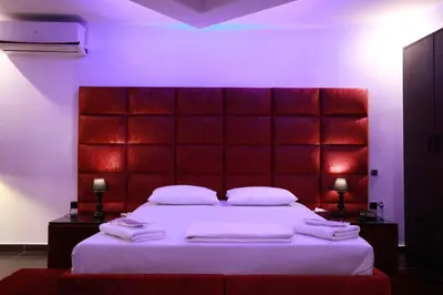 a bedroom with a large bed with a red headboard at Deluxe Suite 214 - Castle De Paris in Athens
