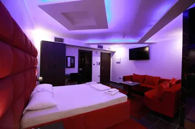 a room with a bed and a couch and purple lights at Deluxe Suite 214 - Castle De Paris in Athens