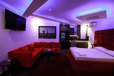 a living room with a red couch and a bed at Deluxe Suite 214 - Castle De Paris in Athens