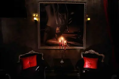 a picture on a wall with two chairs and a candle at Experience Room 101 - Castle De Paris in Athens