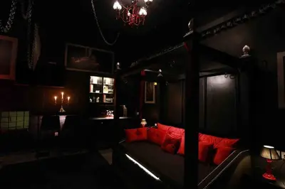 a dark room with a bed with red pillows at Experience Room 102 - Castle De Paris in Athens