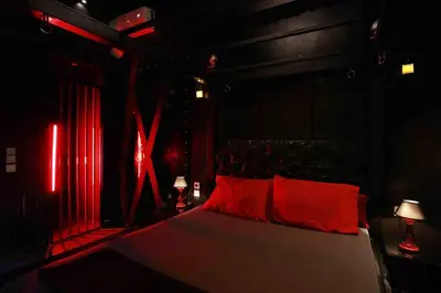 a bedroom with a bed in a room with red lights at Experience Room 102 - Castle De Paris in Athens