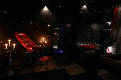 a dark room with two red chairs and candles at Experience Room 104 - Castle De Paris in Athens