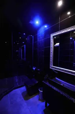 a dark room with a bathroom with a shower and a mirror at Experience Room 104 - Castle De Paris in Athens