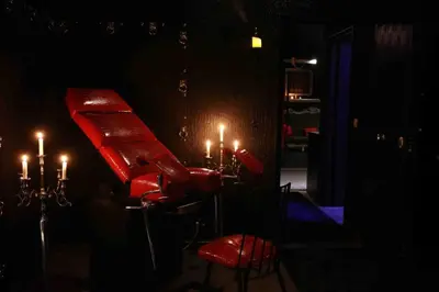 a red bench in a dark room with candles at Experience Room 104 - Castle De Paris in Athens