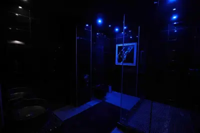 a dark bathroom with a glass shower with a toilet at Experience Room 105 - Castle De Paris in Athens