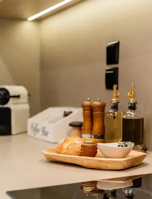 a table with a plate of bread and bottles of wine at Rustic Boutique Apartment with Live Olive Tree & Private Parking in Athens