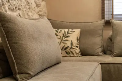 a couch with pillows on it in a living room at Rustic Boutique Apartment with Live Olive Tree & Private Parking in Athens