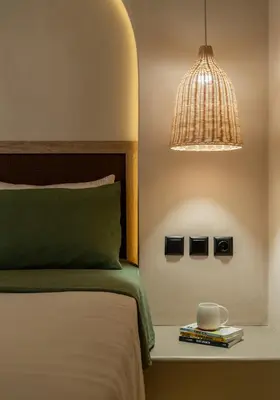 a bedroom with a bed and a lamp and a table with books at Rustic Boutique Apartment with Live Olive Tree & Private Parking in Athens