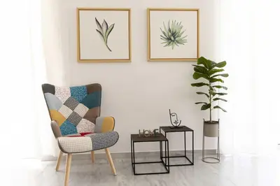 a living room with a chair and a plant at Elegant Apartment in Glyfada A1 in Athens
