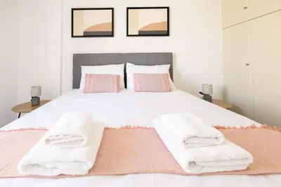 a bedroom with a white bed with towels on it at Elegant Apartment in Glyfada A1 in Athens