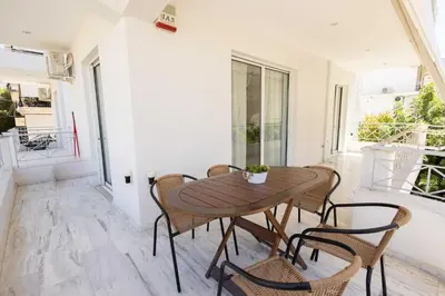 a wooden table and chairs on the balcony of a house at Elegant Apartment in Glyfada A1 in Athens