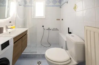 a white bathroom with a toilet and a sink at Elegant Apartment in Glyfada A1 in Athens
