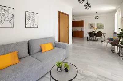a living room with a gray couch and a table at Elegant Apartment in Glyfada A1 in Athens
