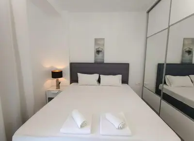 a large white bed with two white towels on it at Coastal Elegance 1-Bedroom Hideaway by the Beach in Athens