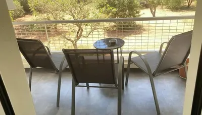 a balcony with two chairs and a table on a porch at Coastal Elegance 1-Bedroom Hideaway by the Beach in Athens