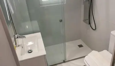 a white bathroom with a shower and a sink at Coastal Elegance 1-Bedroom Hideaway by the Beach in Athens