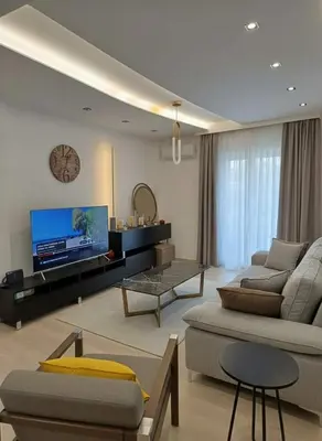 a living room with a couch and a tv at Coastal Elegance 1-Bedroom Hideaway by the Beach in Athens