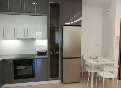 a kitchen with a refrigerator and a table with chairs at Coastal Elegance 1-Bedroom Hideaway by the Beach in Athens