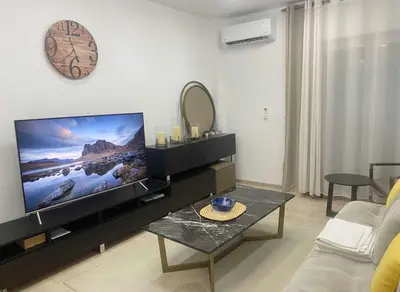a living room with a large flat screen tv at Coastal Elegance 1-Bedroom Hideaway by the Beach in Athens