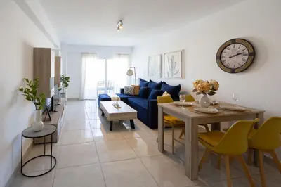 a living room with a blue couch and a table at Bright 2BR flat with city view in Piraeus Η6 in Piraeus