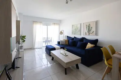 a living room with a blue couch and a table at Bright 2BR flat with city view in Piraeus Η6 in Piraeus