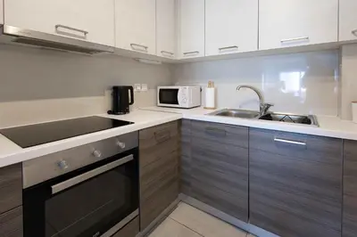 a small kitchen with a sink and a microwave at Bright 2BR flat with city view in Piraeus Η6 in Piraeus