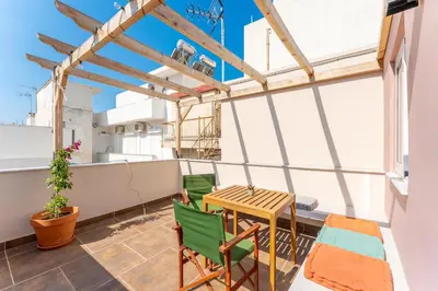 a balcony with a wooden table and chairs at A1 Porto Living in Piraeus