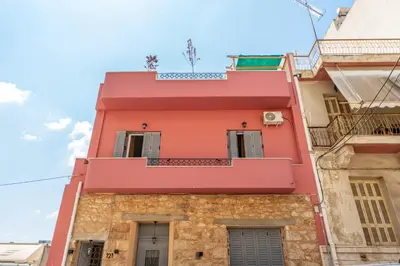 a pink building on a street at A1 Porto Living in Piraeus