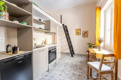 a kitchen with a stove and a table with chairs at A1 Porto Living in Piraeus