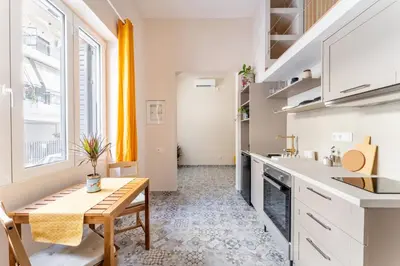 a kitchen with white counters and a table and a table sidx sidx sidx at A1 Porto Living in Piraeus