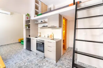 a kitchen with white cabinets and a staircase at A1 Porto Living in Piraeus
