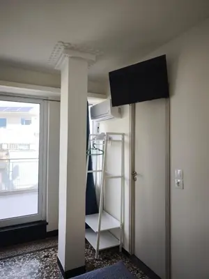 a room with a pillar with a television on the ceiling at Athens Commercial Premium in Athens